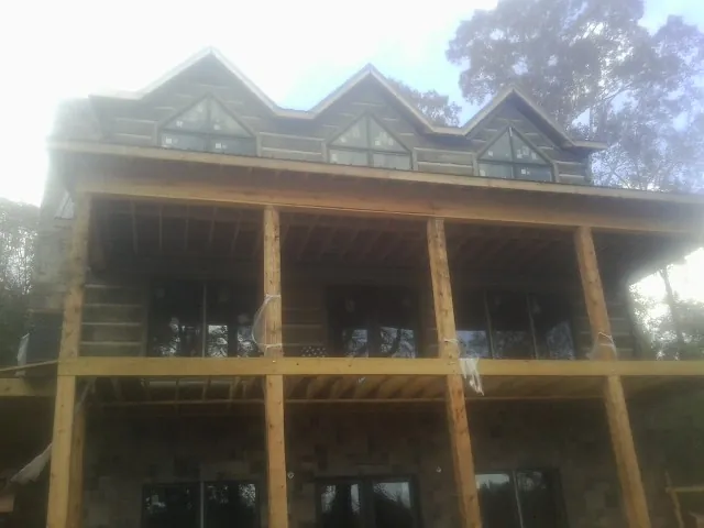 Dormers and porch framing on a large log home under construction — Roof Coating work by our crew in Boiling Springs