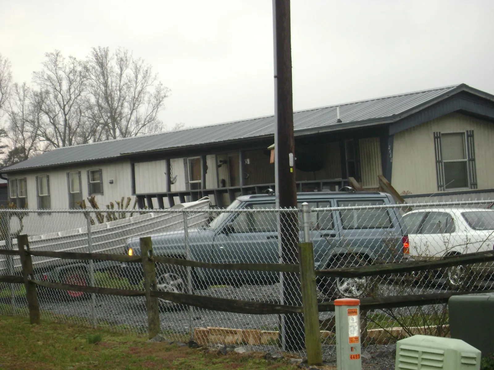 Dark metal roof on a long single story building behind a chain link fence in Boiling Springs