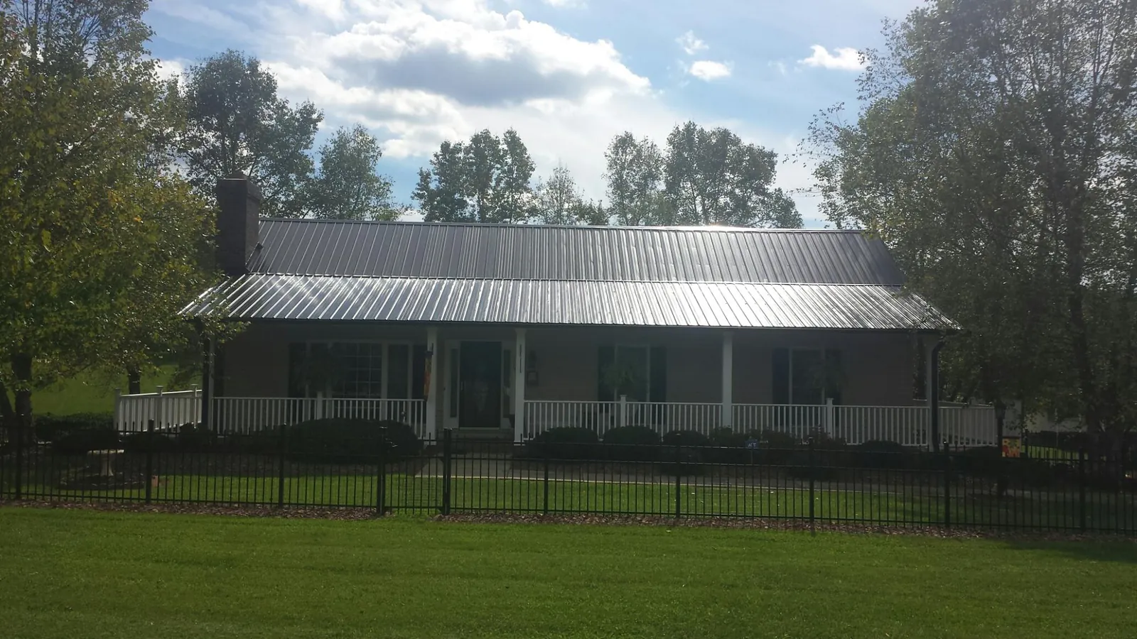 Gray metal roof on a brick ranch with a full width front porch — Gutter Guard Installation work by our crew in Boiling Springs
