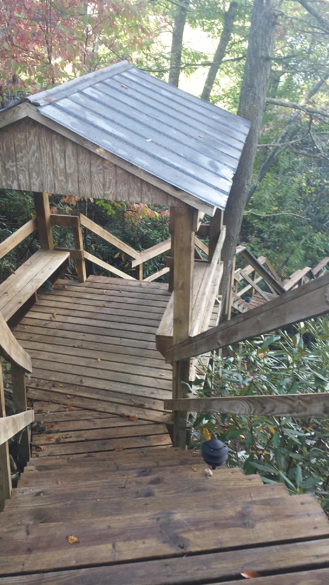 Metal roofed shelter over wooden steps on a wooded walkway — Skylight Repair & Installation work by our crew in Boiling Springs